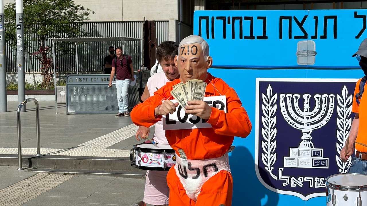 A demonstrator stands in front of a giant ballot box.
