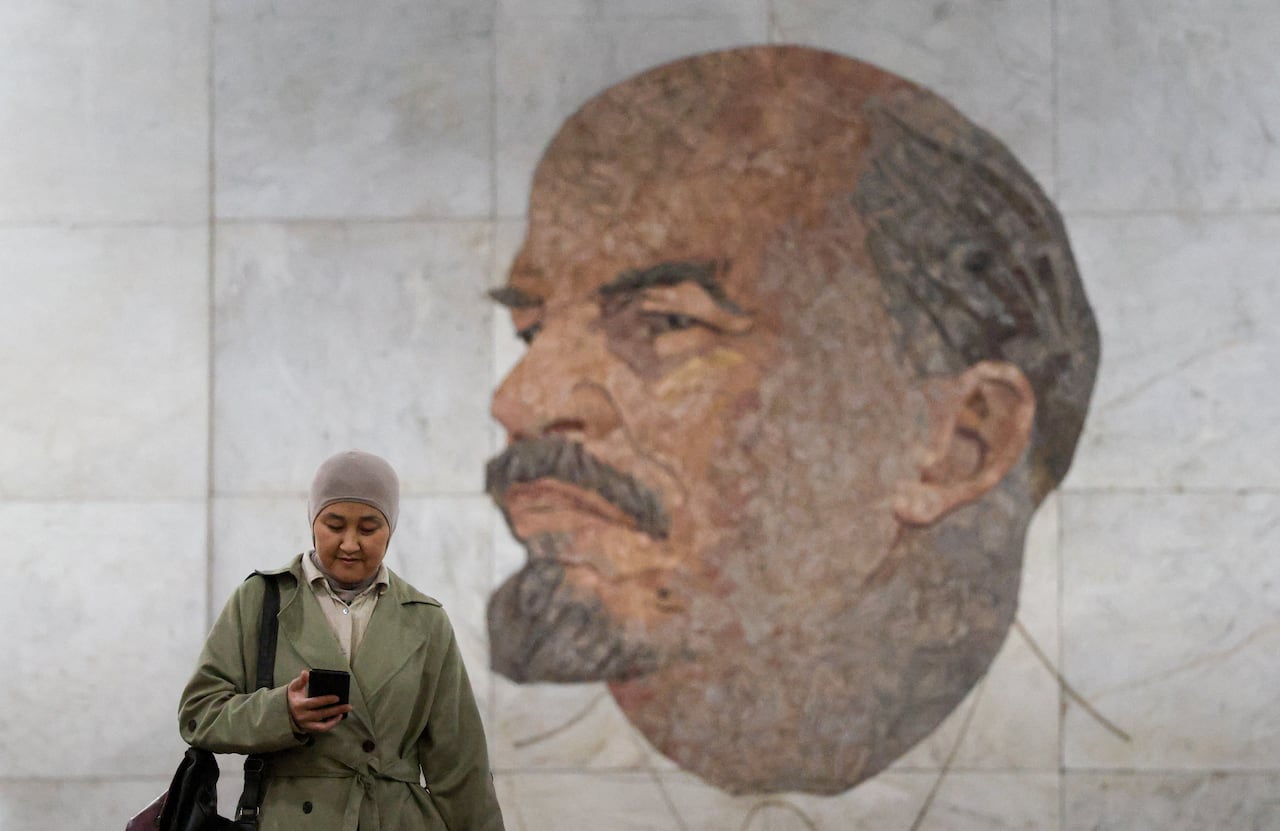 A passenger uses a mobile phone while walking in front of a mosaic depicting Soviet state founder Vladimir Lenin at Biblioteka Imeni Lenina (Lenin Library) metro station in Moscow, Russia, March 31, 2026. REUTERS/Ramil Sitdikov