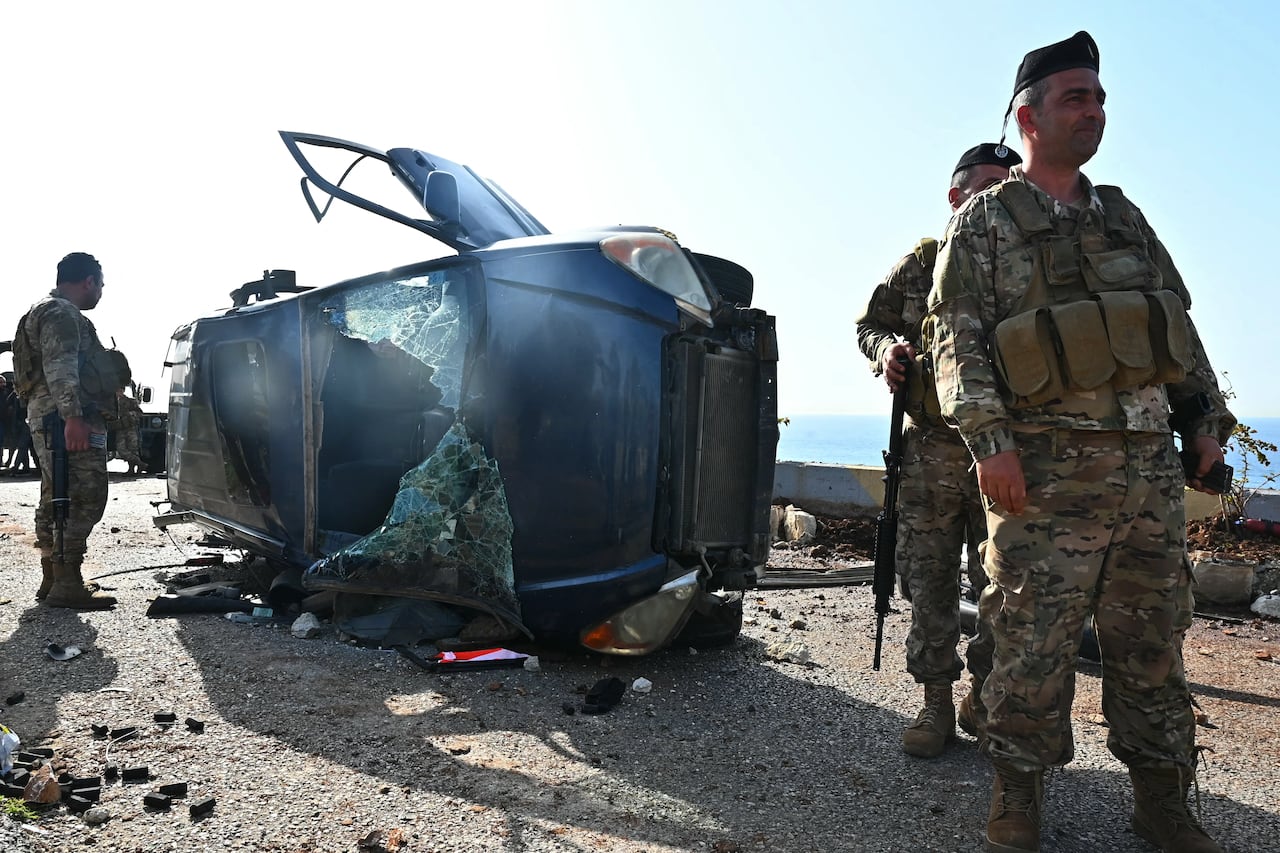 Lebanese army soldiers at site of Israeli drone attack on a vehicle on a highway south of Beirut
