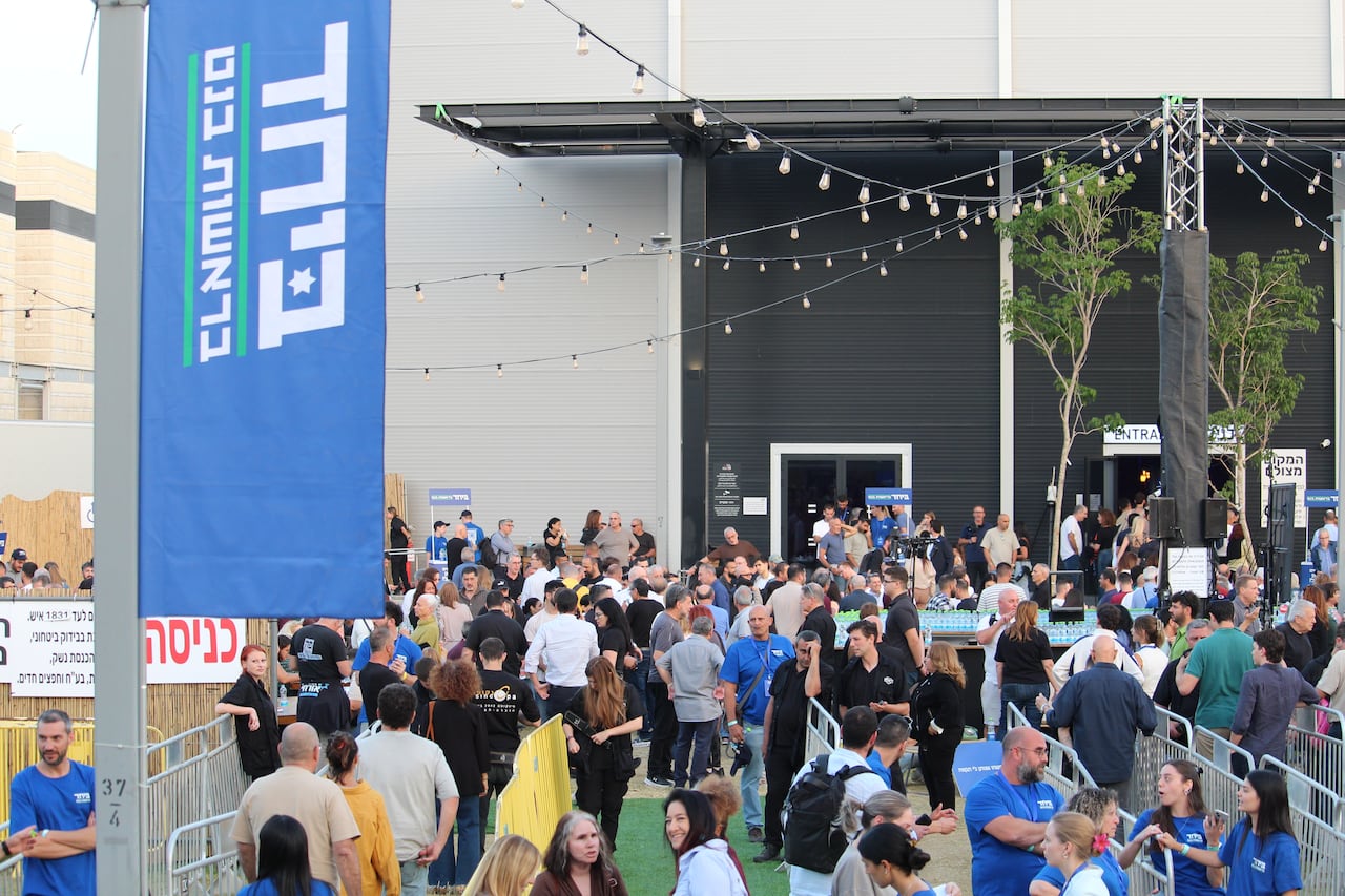 A crowd stands in front of a building.