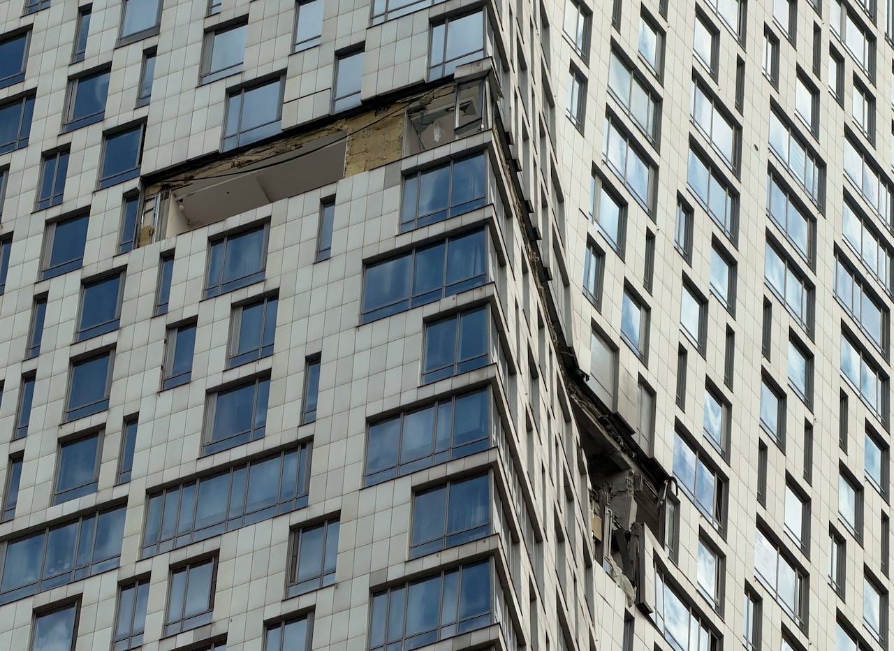 A closeup of damage to windows and walls of a high-rise building.