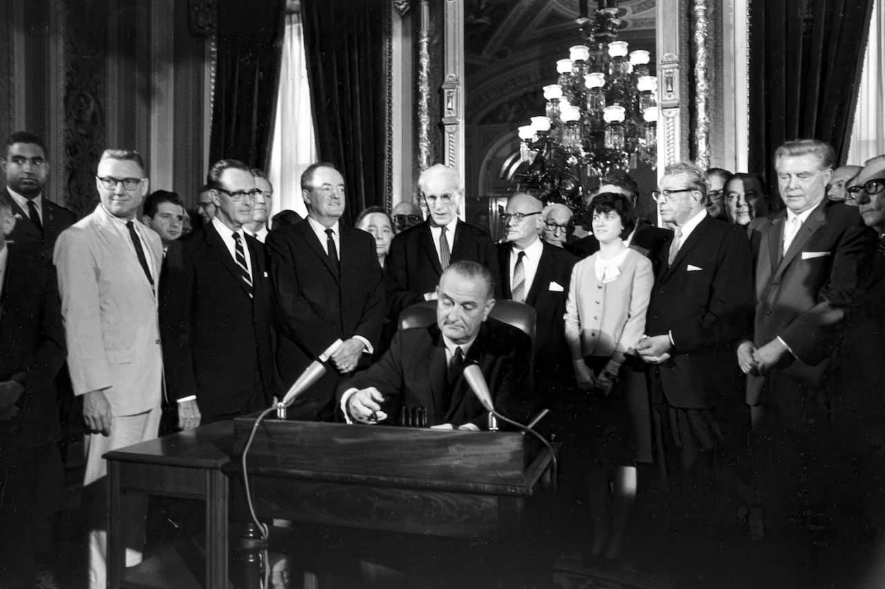 President Lyndon B. Johnson signs the Voting Rights Act of 1965 in a ceremony in the President's Room near the Senate chambers in Washington, Aug. 6, 1965.