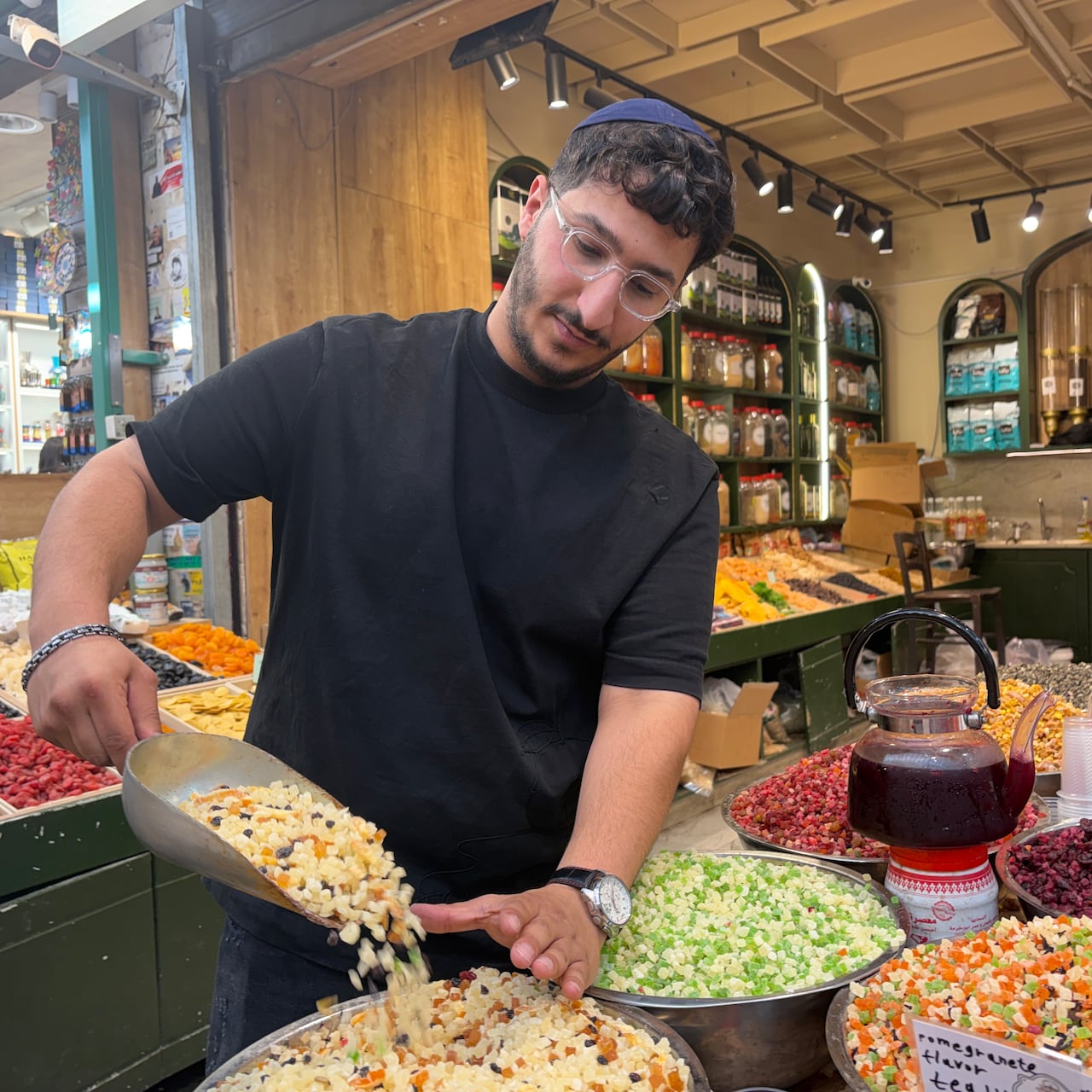 A person pours a scoop of food into a bowl in a shop.