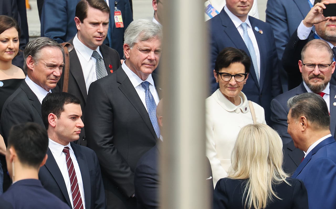 A small group of men and women in business attire seen from a distance.