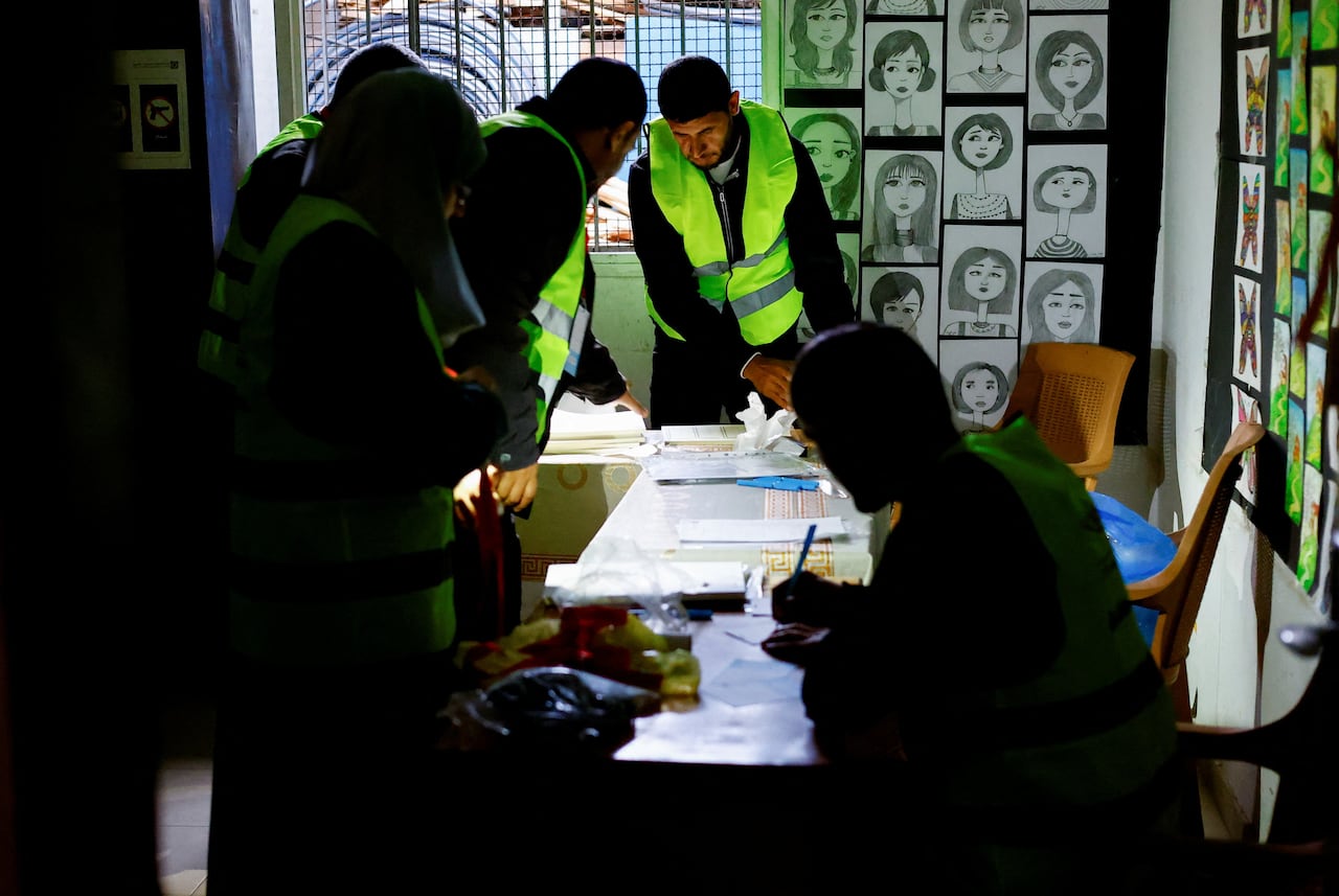 Election works look at documents on a table.
