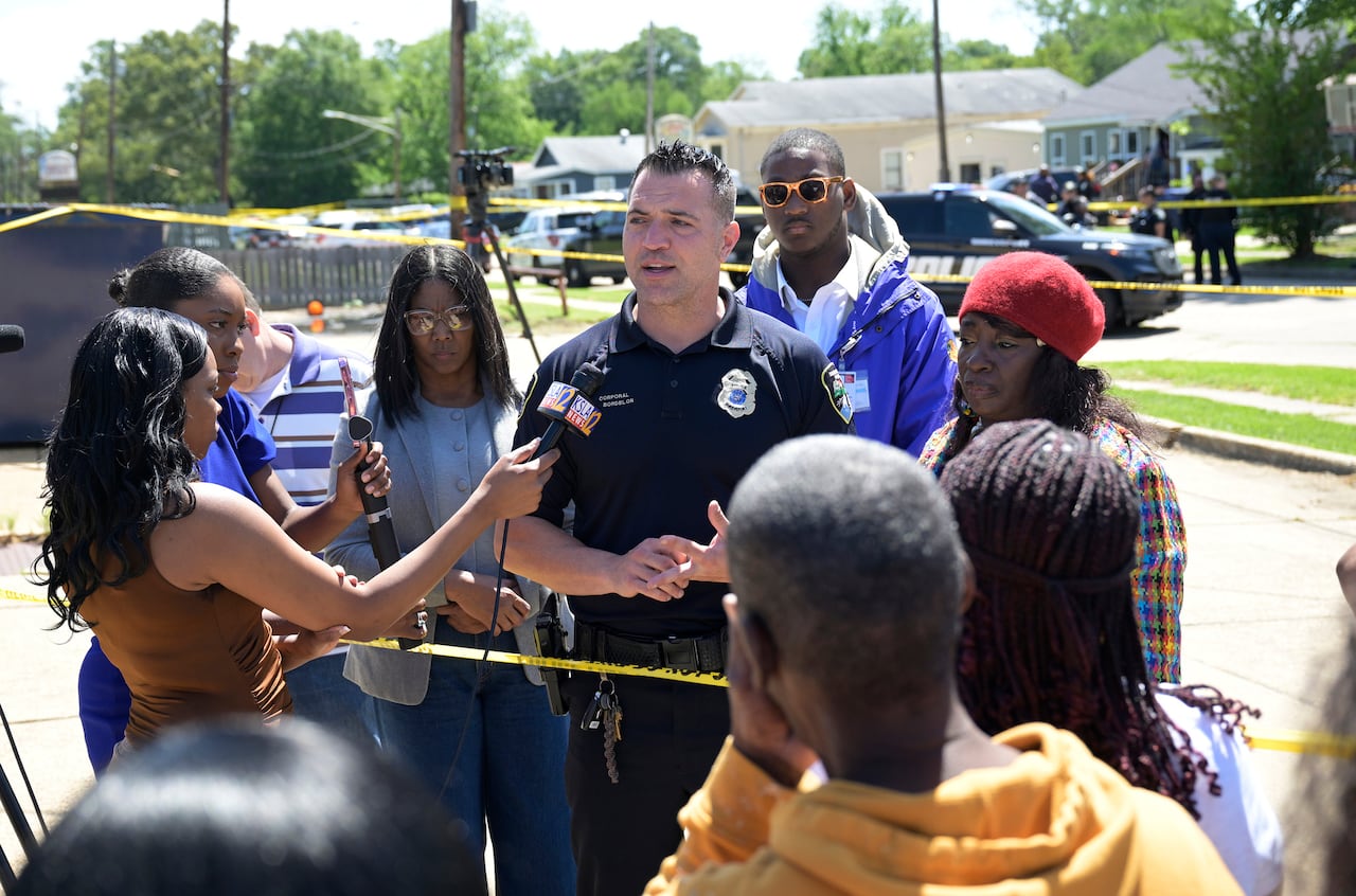 Reporters interview a police officer