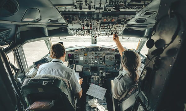 Pilots are seen inside a cockpit.