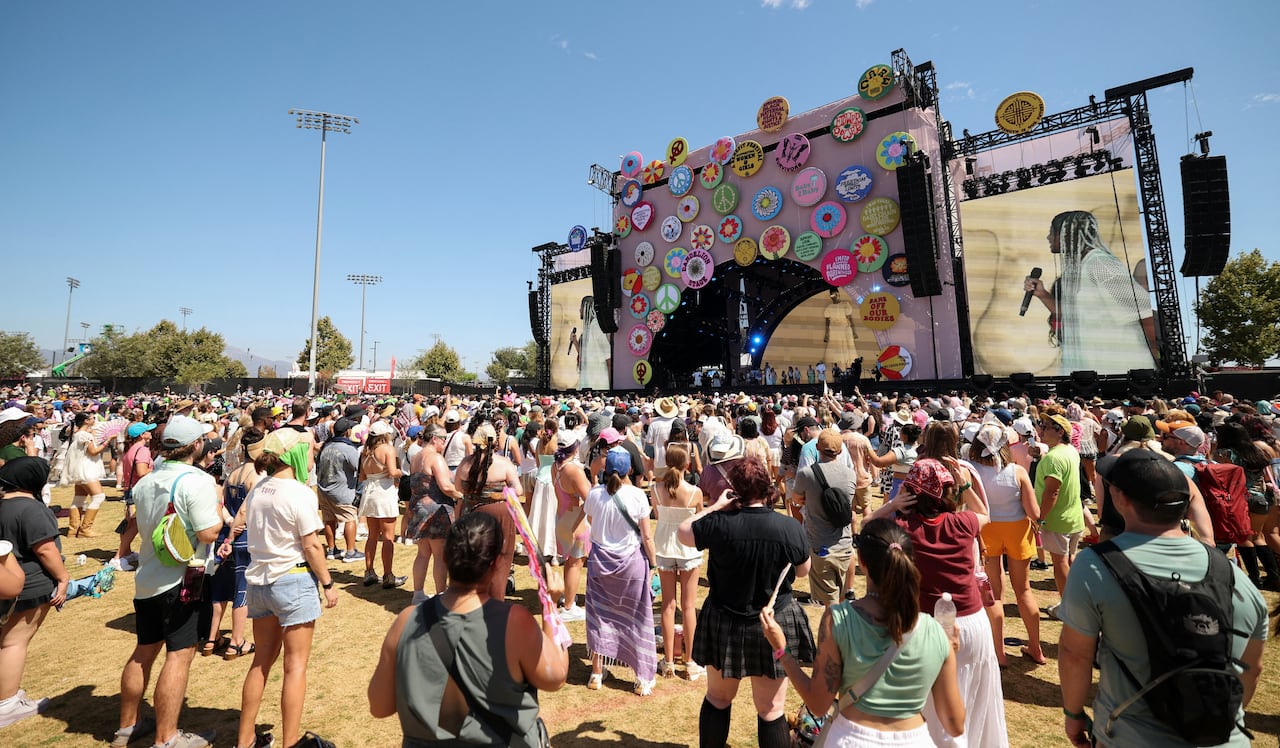 An outdoor stage and the crowd in front of it are shown.