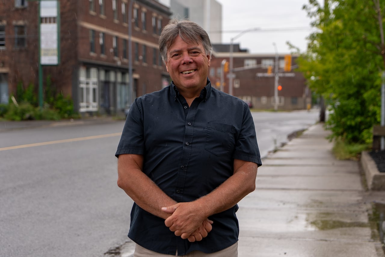 A person is seen standing on a sidewalk.
