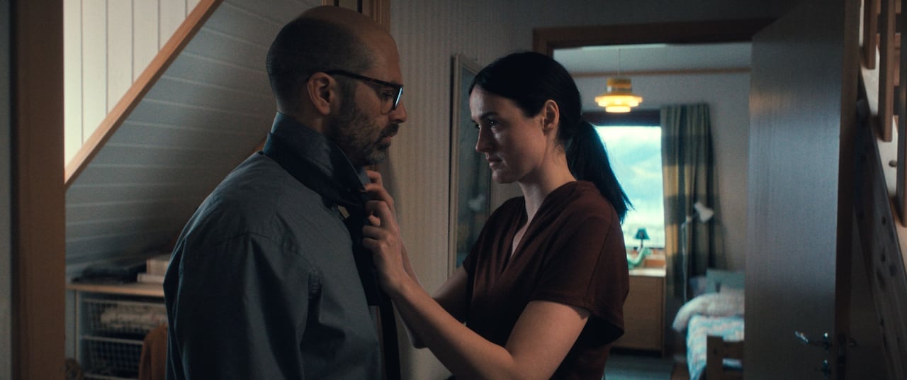 A woman ties a man's tie.