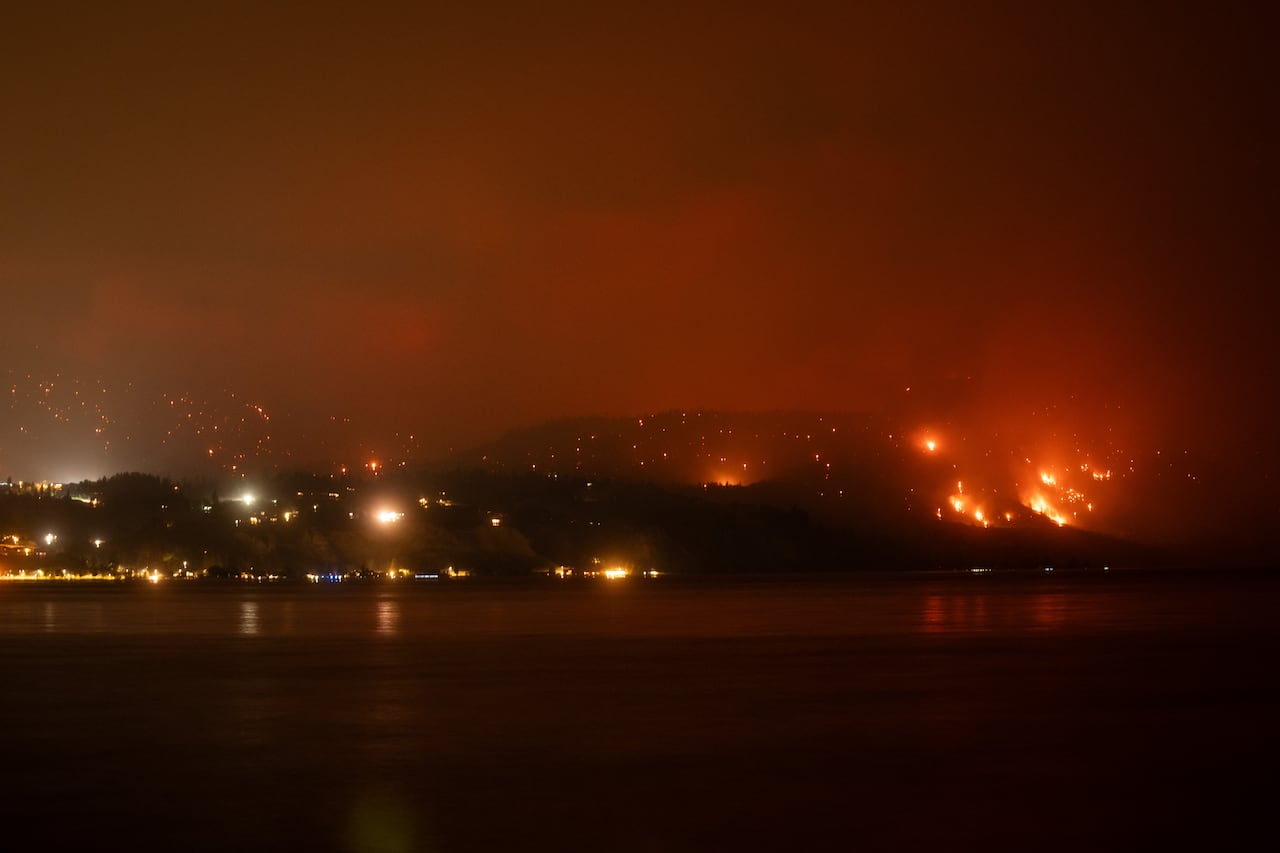 夜间山火燃烧的湖滨社区远景