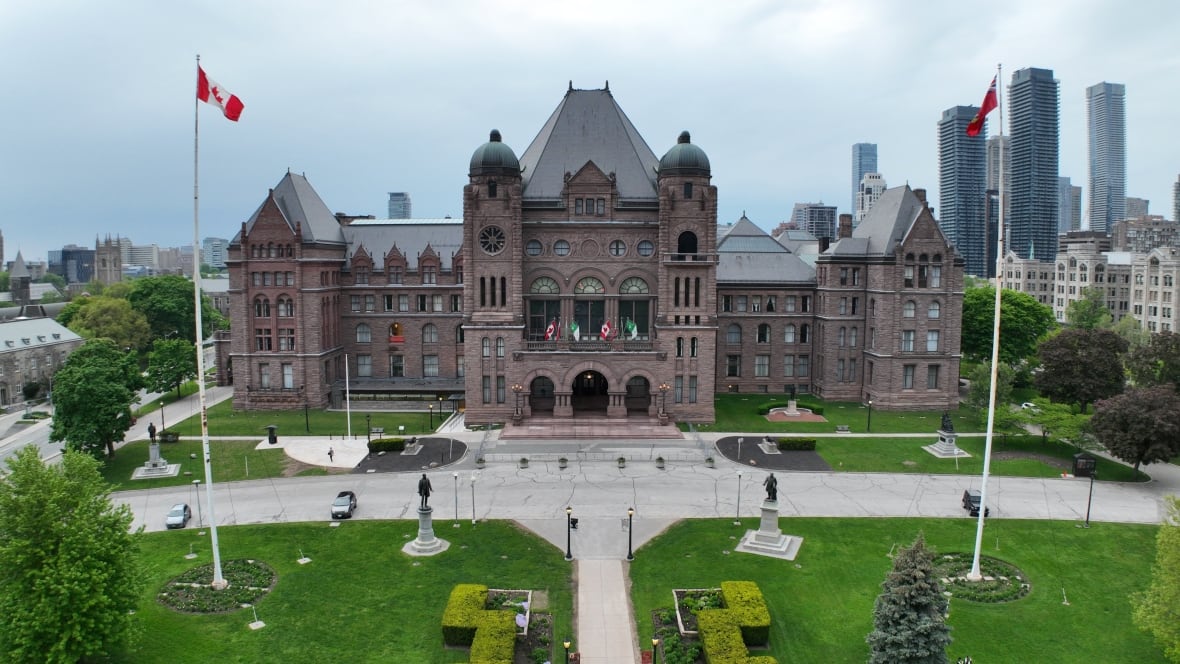 A drone image of a big legislative building with flags. 