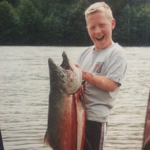 Cameron Kerr as a child, holding a fish.
