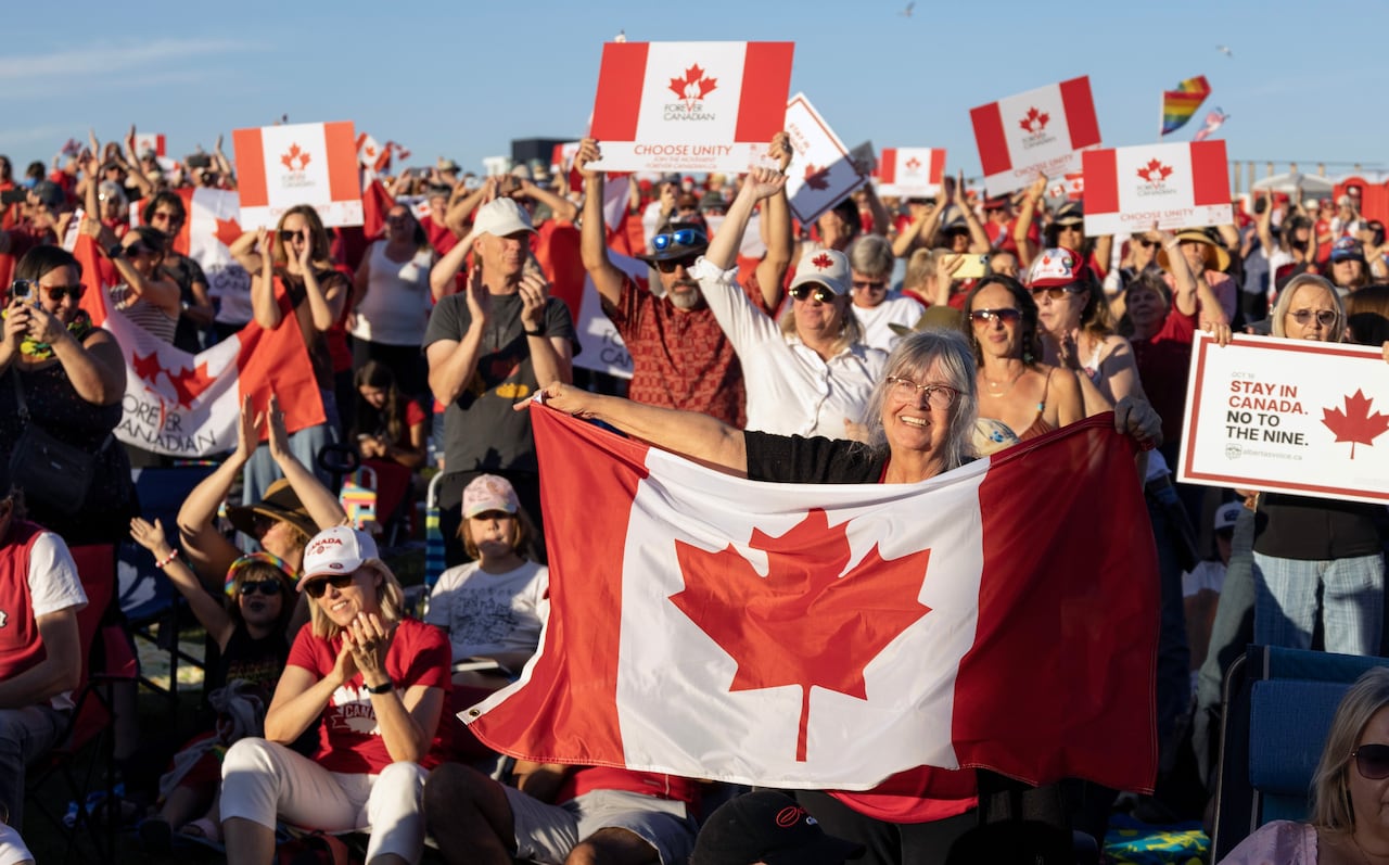 A crowd of people holding Canadian flags.