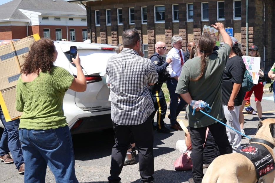 man being led by a police officer