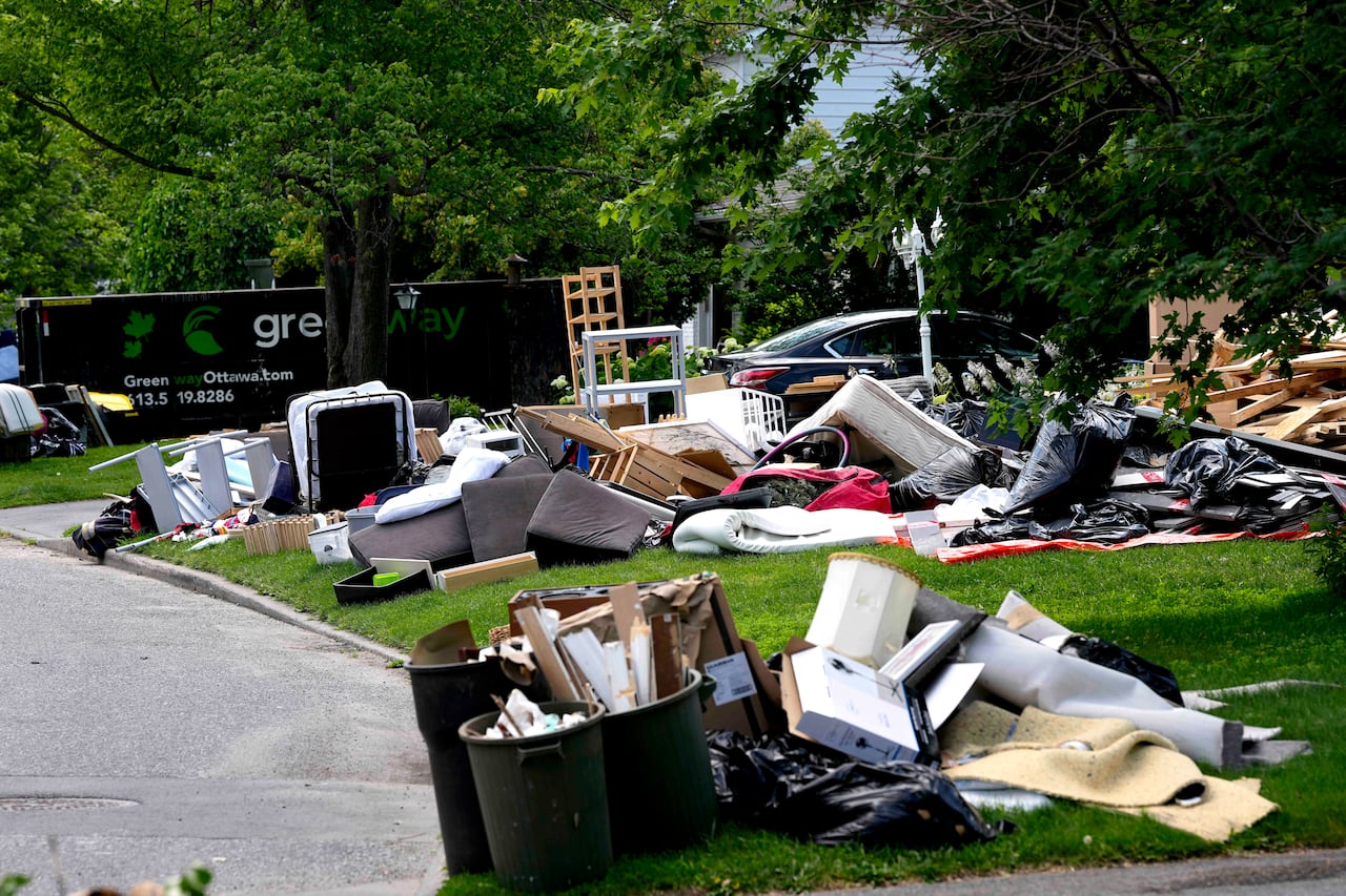 Belongings damaged after a storm on Canada Day flooded basements are seen on lawns to await disposal, in the Qualicum – Graham Park neighbourhood of Ottawa, on Tuesday, July 7, 2026.