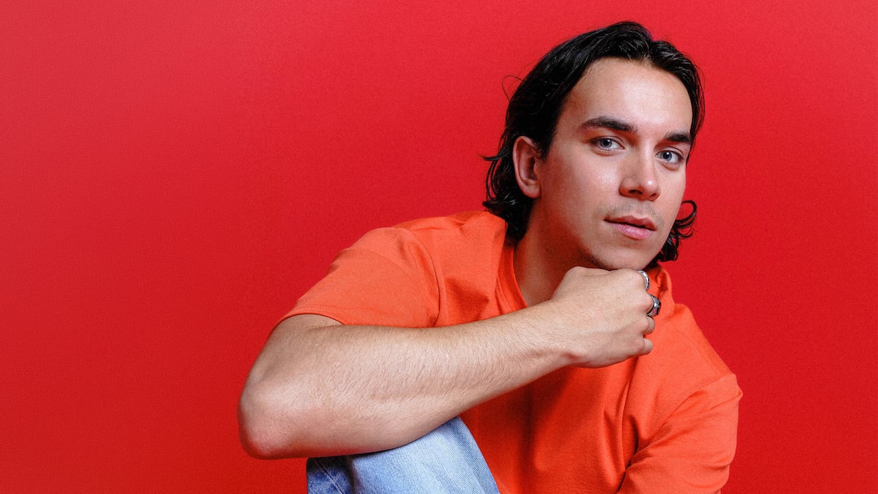 Man in orange looks at camera.