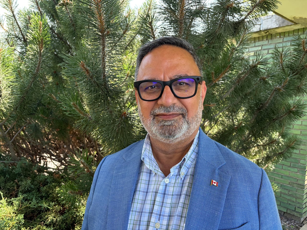 A man with glasses and a blue suit
