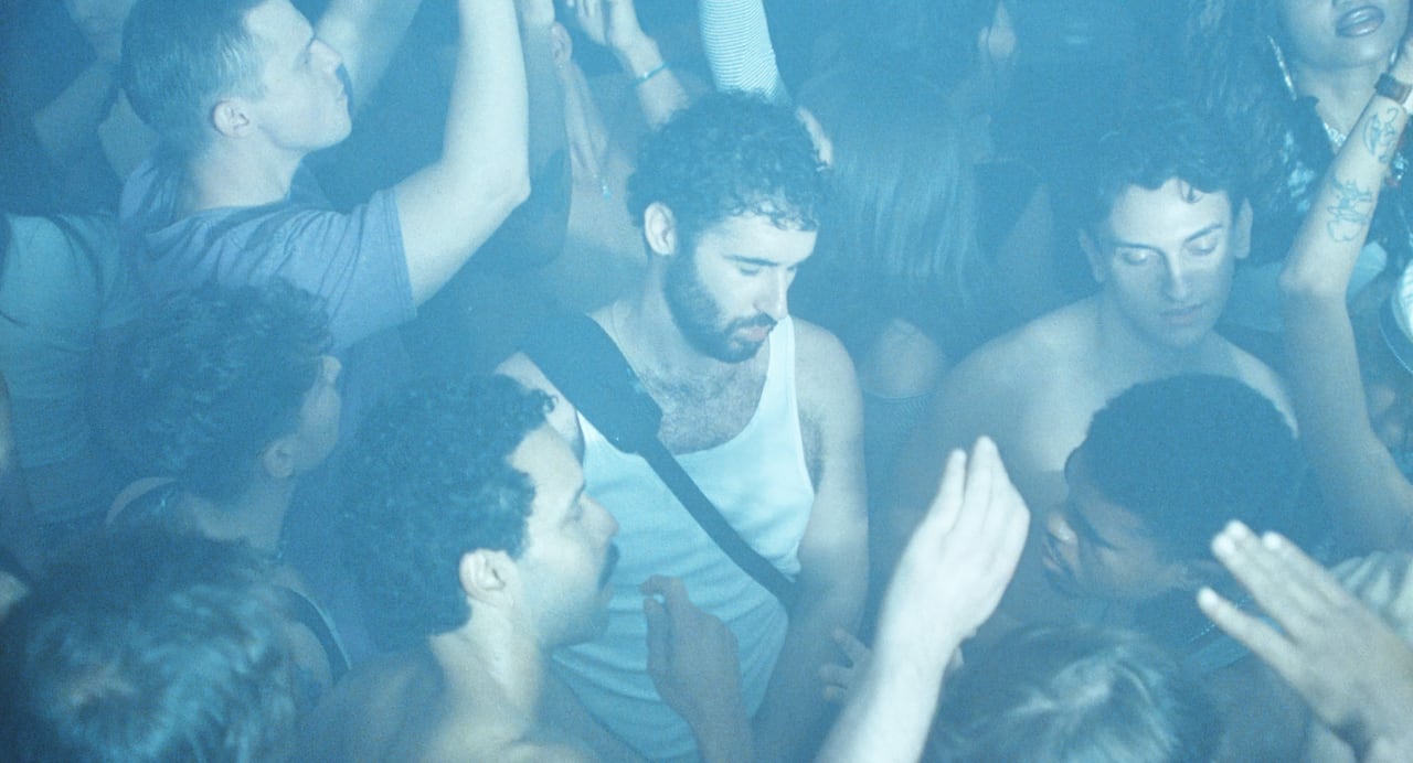 A man dances in the middle of a large crowd in a nightclub.