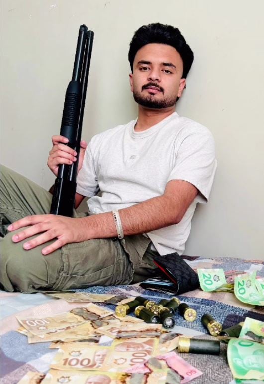 Sahibjot Singh poses with a gun, money and bullets in an image downloaded from his phone. He told CBSA officers the picture was "just for fun."