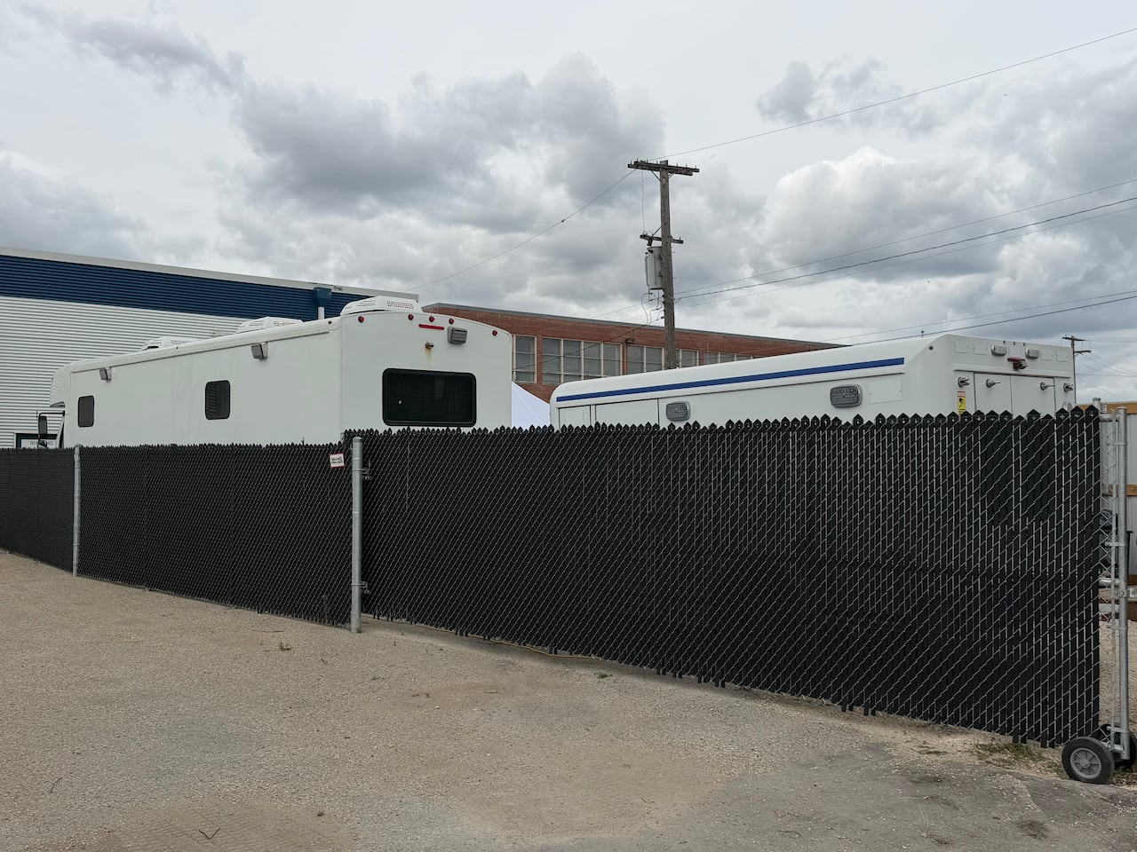 An RV and another vehicle behind a fence