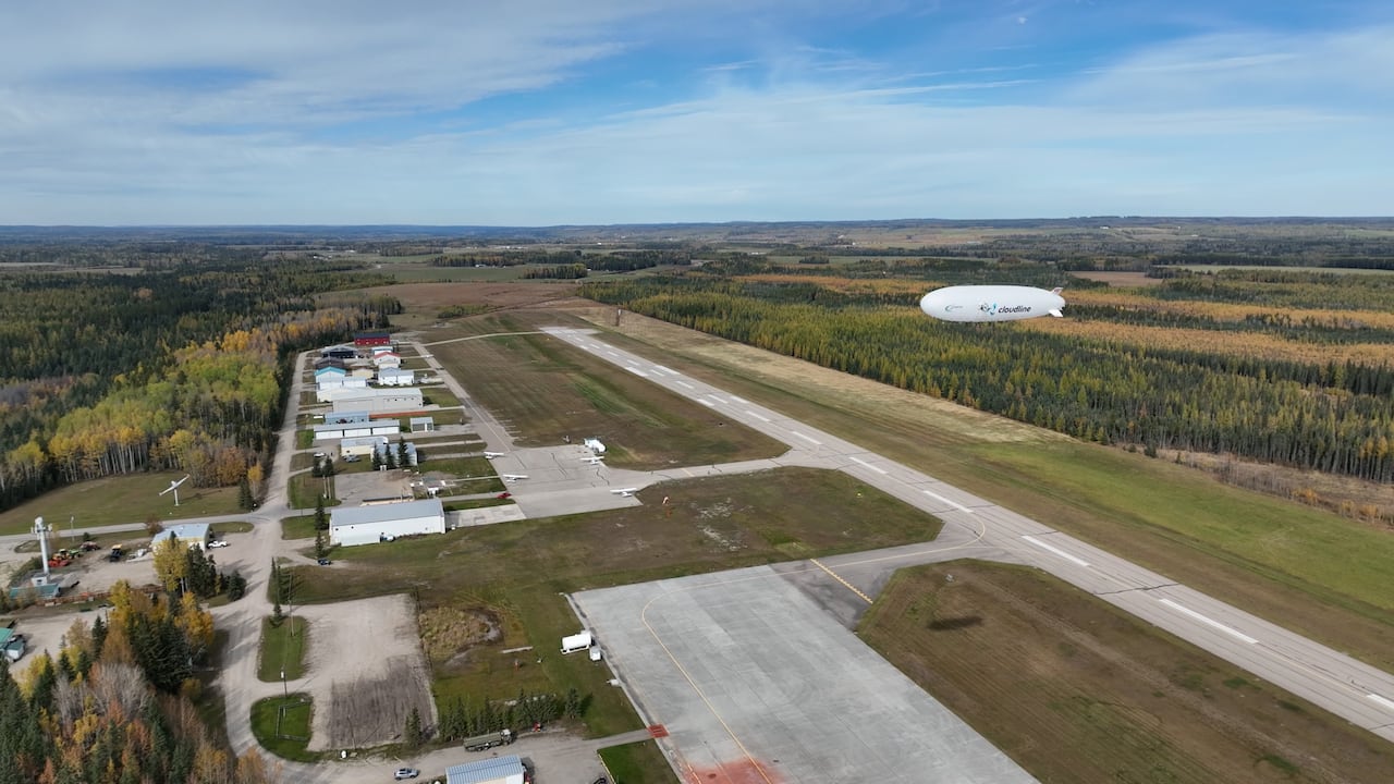 An airship hovering over an airport runaway strip