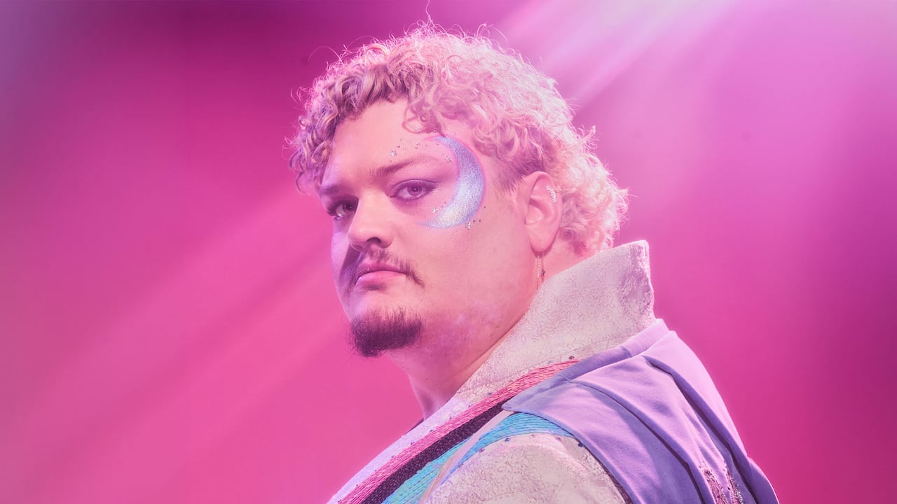 Man with makeup and blonde curly hair.