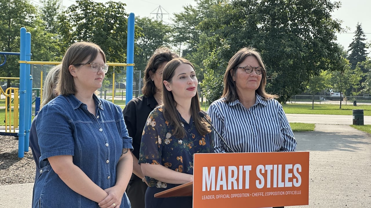 五名女性在游乐场讲台前发言，讲台上有“Marit Stiles”标志。