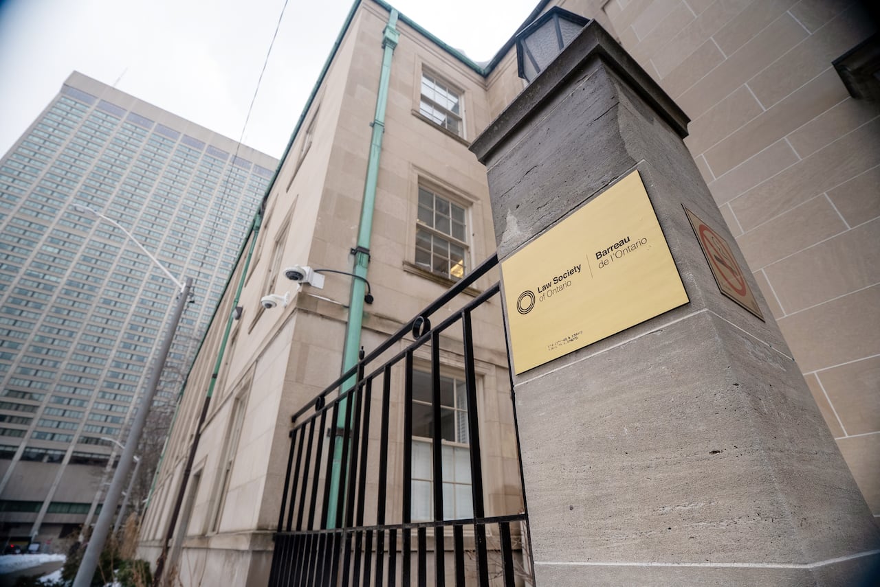 A building with a sign on a gatepost that reads, Law Society of Ontario.