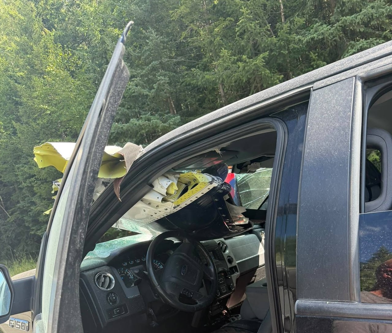 A pickup truck with debris smashed through the front windshield.