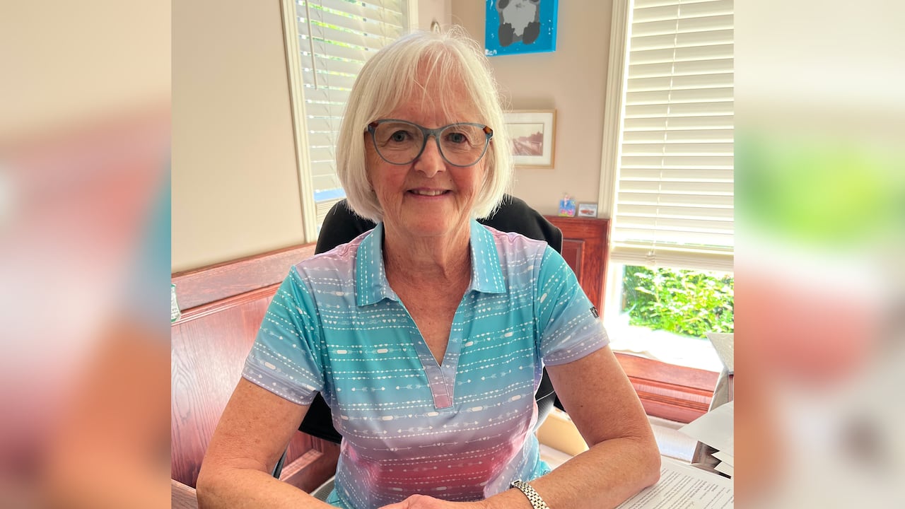 A woman sits smiling.