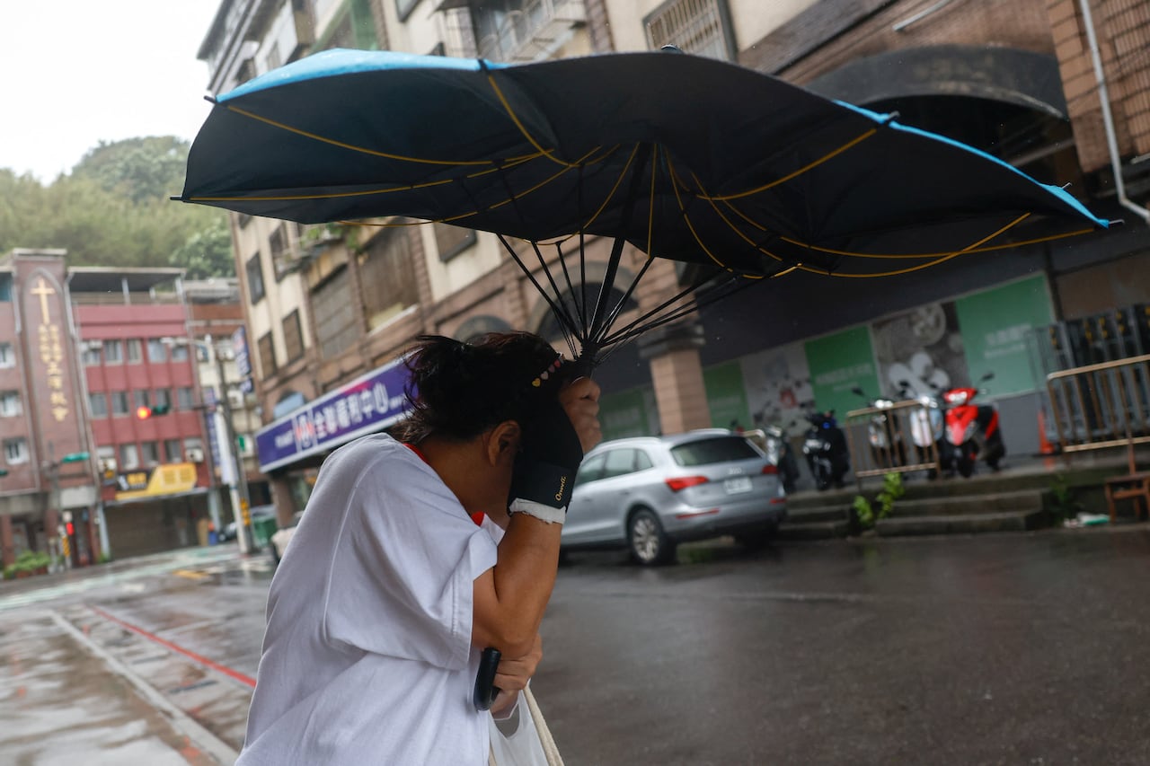 行人在风雨中挣扎撑伞