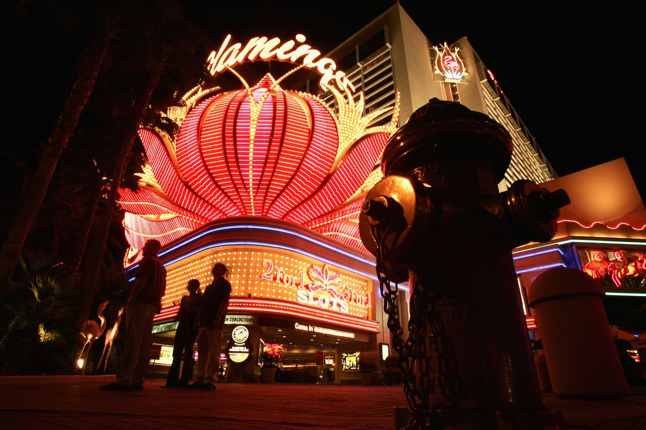 A night view of a brightly lit hotel exterior featuring neon signage.