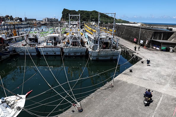 Fishing boats are tied to a dock in a harbour in anticipation of a typhoon