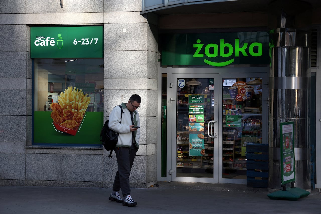 the storefront of a grey building is pictured with a green sign reading "zabka"