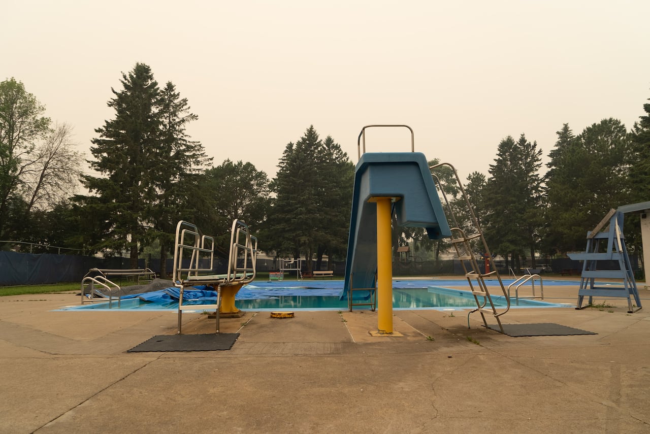 A pool is seen beneath a yellow, smoky sky.