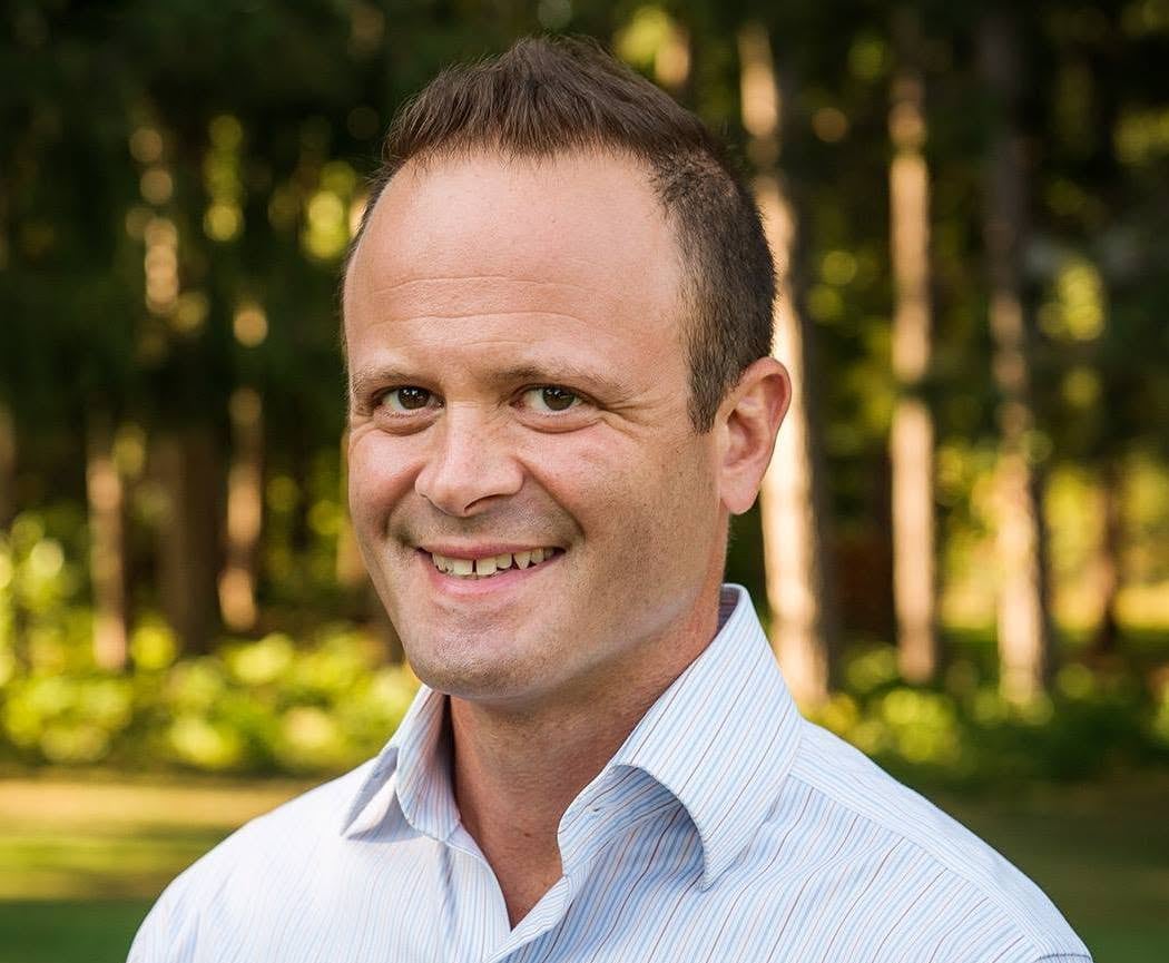 A man smiles for a portrait.
