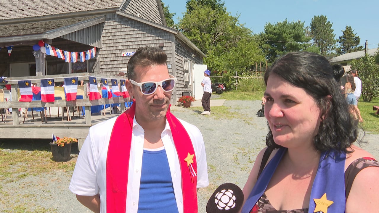 A man and a woman stand side by side during a media interview.