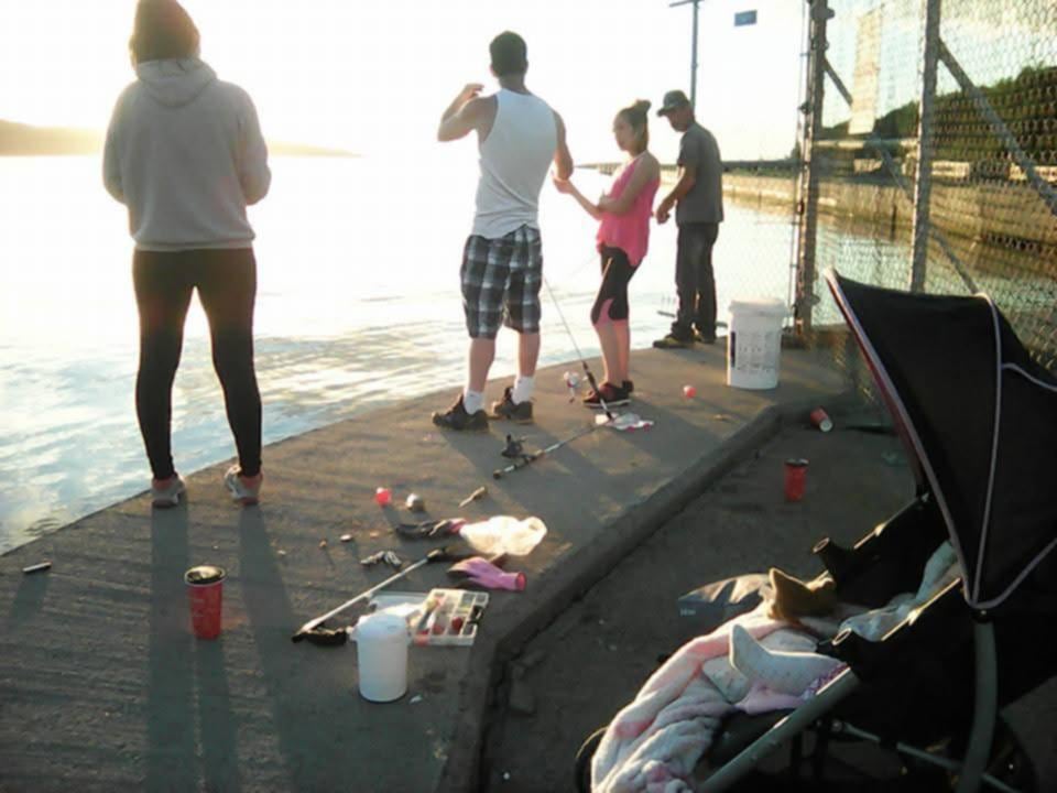 several people, including children, fishing on rock