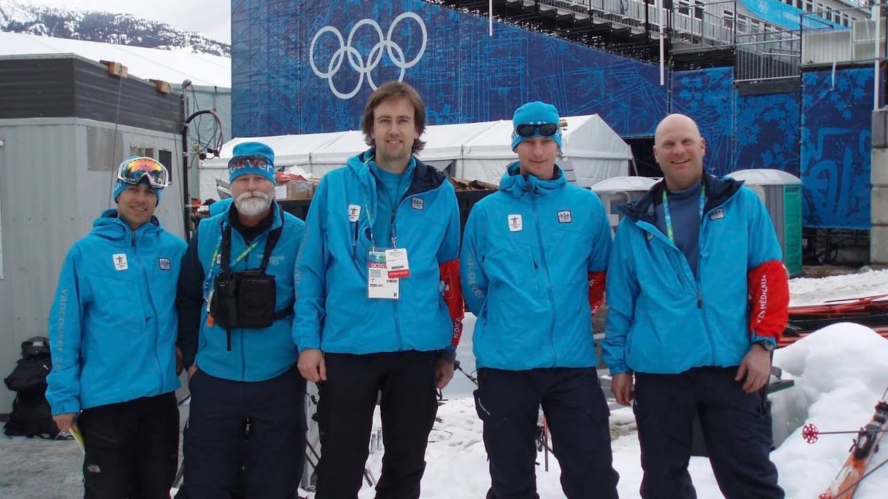 Five people in blue jackets