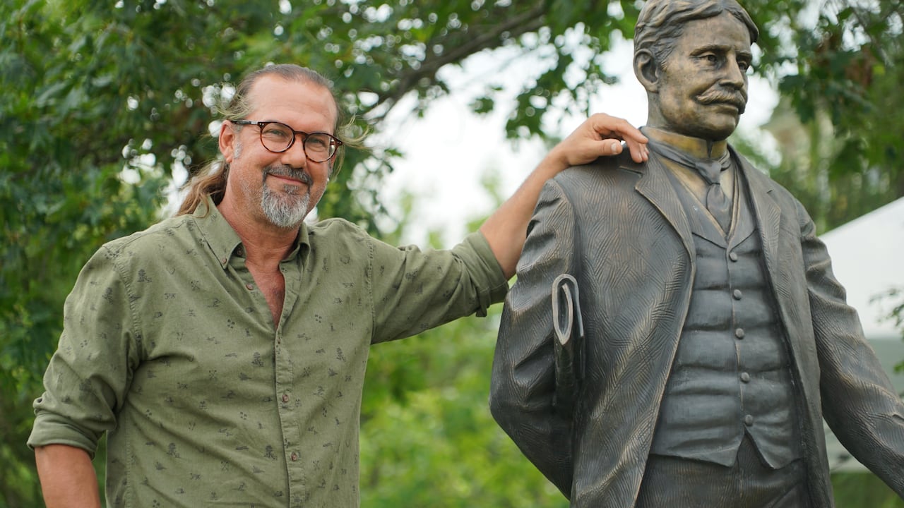 Nathan Scott leans his arm on his sculpture of Sir Robert Borden. Scott, also the sculptor behind 'The Unfortunate Four,' had finished the sculptures in 2019 but was forced to hide them following backlash.