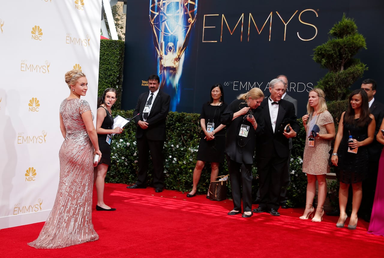 A woman in a gown poses on the red carpet at the Emmy Awards.