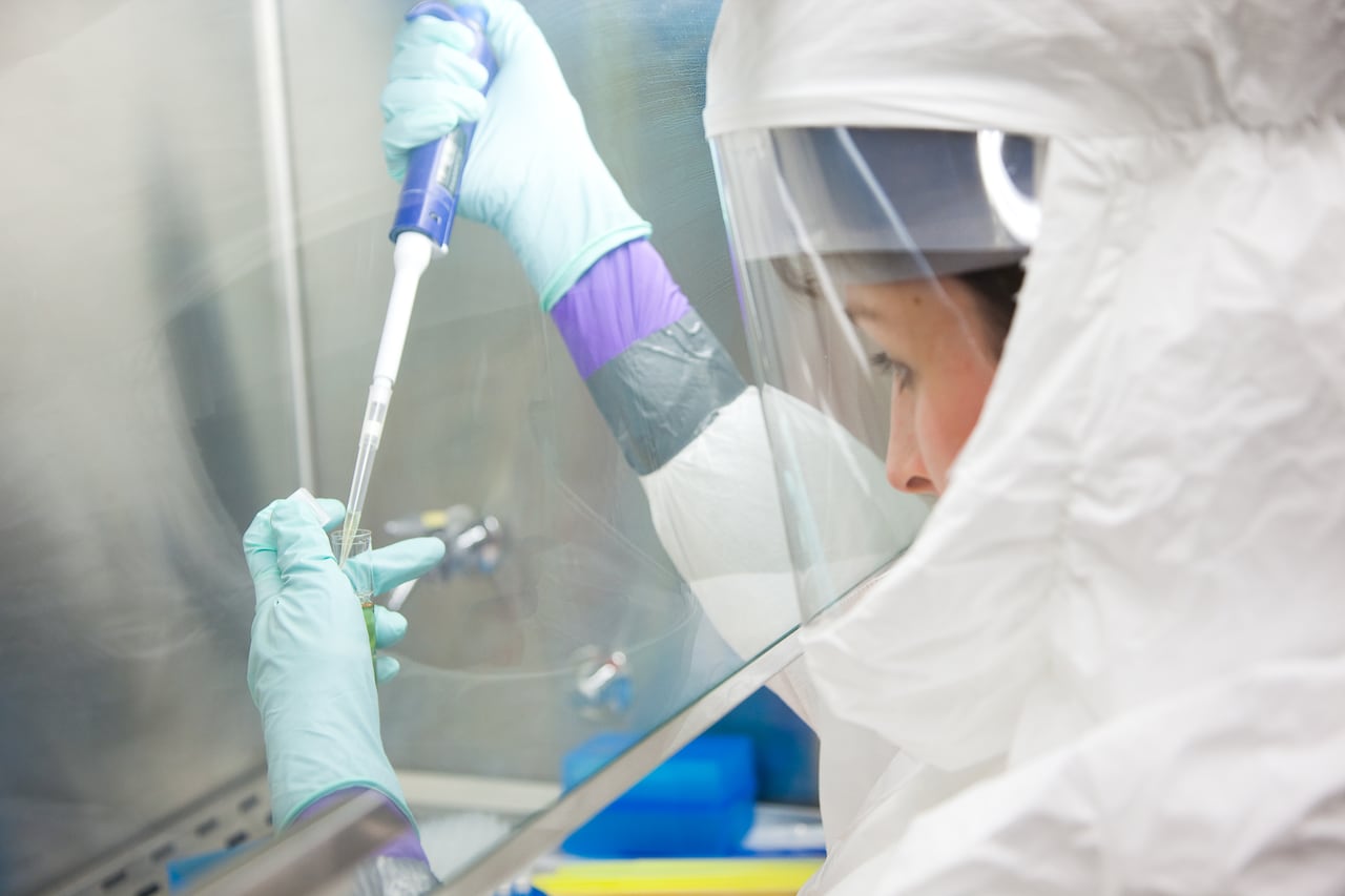 A closeup of a person in protective lab gear.