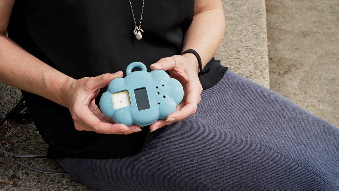 blue, cloud-shaped sensor held between someone's hands