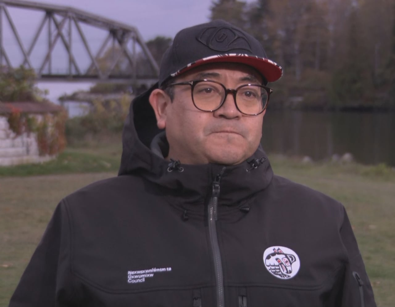一名原住民男子站在桥和海岸前