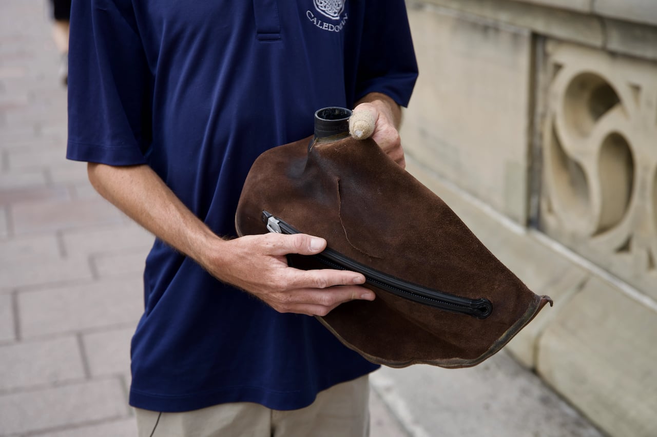 A man holds a brown bag.
