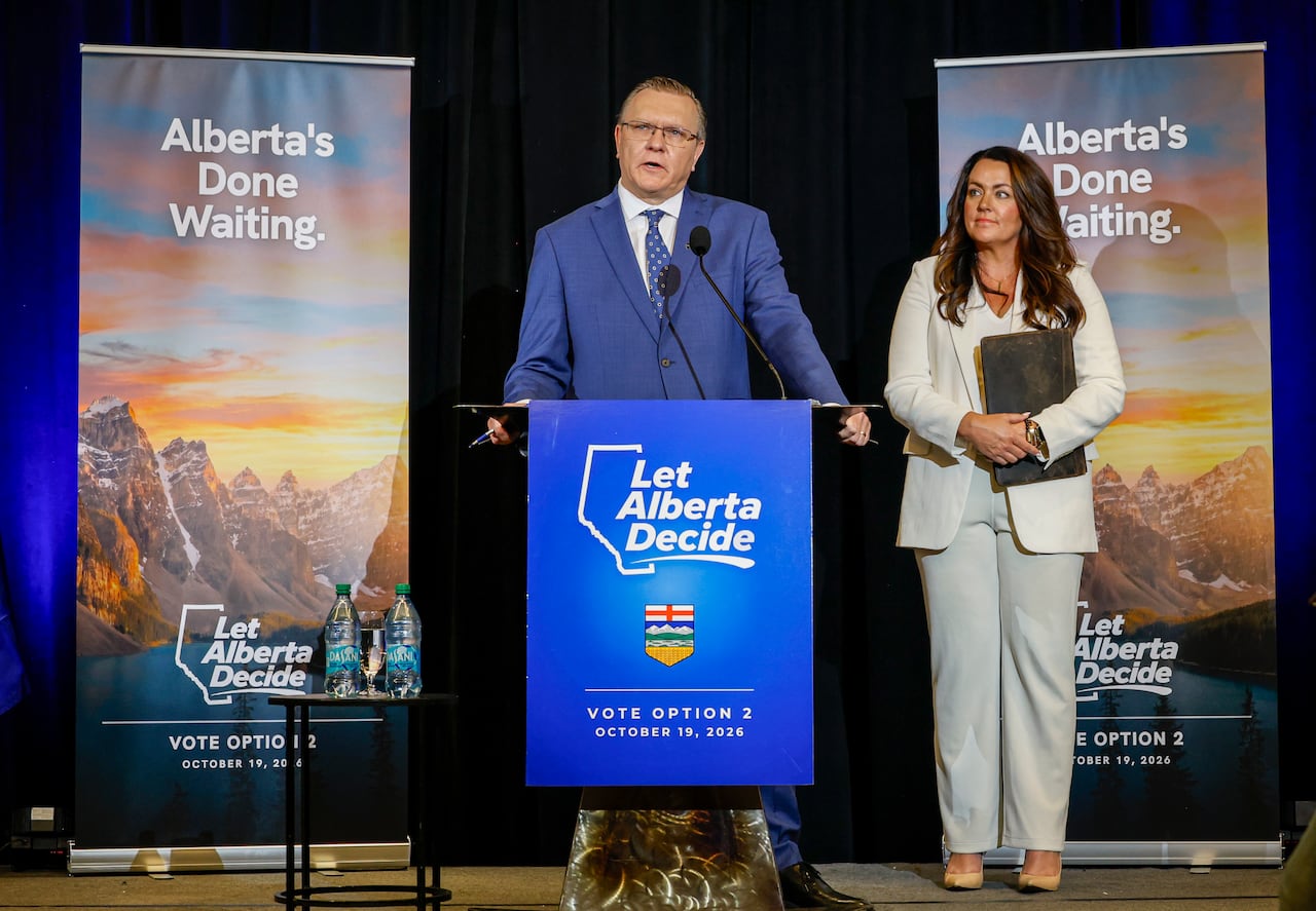 Two people stand in front of a podium.