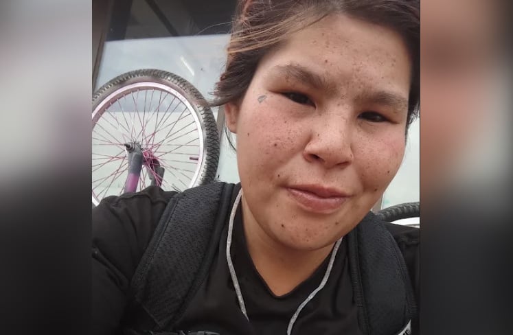A selfie of a woman with dark hair tied back.