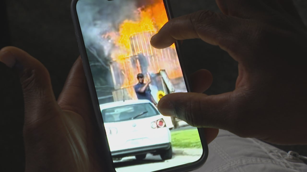 Black man points to himself in a video on a cellphone.