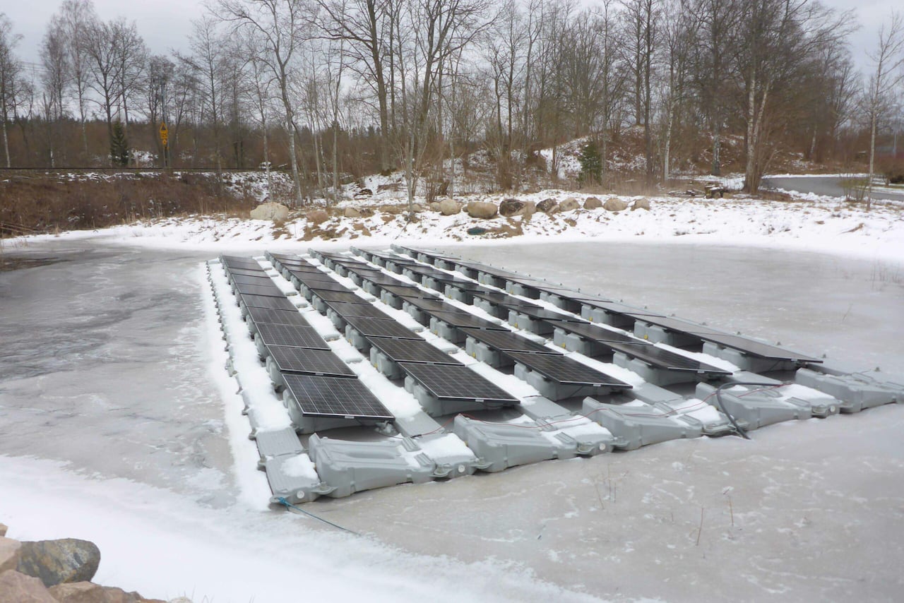 An array of solar panels that appear to be sitting on ice